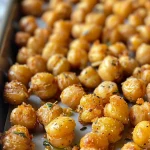 Juicy roasted chickpeas sprinkled with spices, showcasing their crunchy exterior.