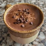 A detailed shot of a chocolate protein mug cake with melting chocolate chips.
