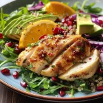 Juicy Citrus Chicken Quinoa Salad adorned with avocado and pomegranate seeds.