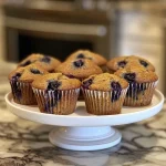 A detailed side view of baked diabetic blueberry muffins, highlighting the moist interior and glossy blueberry toppings.