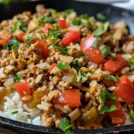 Juicy turkey rice skillet filled with ingredients, garnished with fresh parsley.