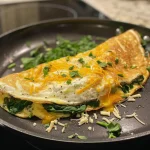 Appetizing keto omelet filled with spinach and melted cheese, served warm.