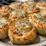 Close-up side view of golden-brown homemade chicken pizza rolls, showcasing melted cheese and a crispy crust.