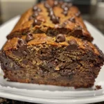Close-up view of a slice of chocolate chip banana bread showcasing melted chocolate chips.