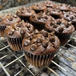 Side profile of a fluffy chocolate chip protein muffin, emphasizing its soft interior and rich chocolate flavor.