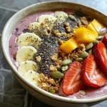Thick smoothie bowl with vibrant frozen fruits and a drizzle of honey, served in a bowl.
