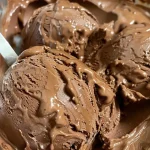 Close-up view of rich fudge brownie ice cream with chunks of brownie and chocolate chips.
