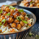 Close-up of a vibrant 15-Minute Teriyaki Chickpea Rice Bowl garnished with green onions and sesame seeds.