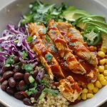 A colorful BBQ Ranch Chicken Quinoa Bowl featuring chicken, quinoa, black beans, and fresh vegetables.
