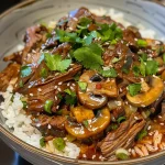 A close-up view of a beef bowl filled with BBQ brisket, garnished with fresh cilantro.