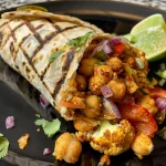 Close-up of a colorful chili lime chickpea cauliflower wrap showcasing vibrant ingredients.