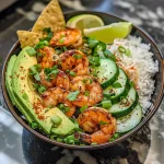 Close-up view of a colorful Chili-Lime Shrimp Bowl with fresh avocado and cucumber salad.