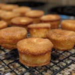 Close-up view of golden-brown mini donut muffins coated in cinnamon sugar.