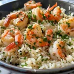 A side view of a bowl filled with creamy herb rice and garlic butter shrimp.