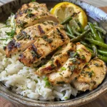 Close-up of creamy lemon herb chicken rice bowl garnished with green beans.
