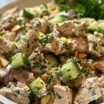 Close-up of creamy lemon herb tuna salad in a bowl, garnished with fresh herbs.