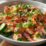 Close-up view of a vibrant Easy Spicy Tuna Salad featuring diced cucumber and avocado.