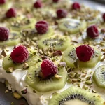 Close-up view of Frozen Yogurt Bark topped with fresh fruits and nuts.