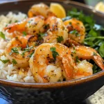Close-up view of a garlic butter shrimp bowl with creamy herb rice and fresh parsley.