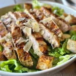 Close-up view of a Grilled Chicken Caesar Salad with juicy chicken, crisp romaine, and croutons.