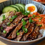 A close-up view of Korean BBQ steak rice bowl with colorful toppings.