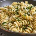 Close-up view of a vibrant Lemon Parmesan Pasta Salad with rotini pasta and fresh parsley.