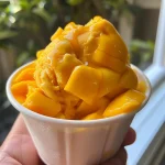 Close-up view of creamy Mango Frozen Yogurt in a bowl.