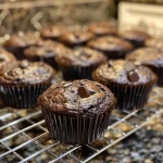 Close-up view of a moist brownie muffin with chocolate chips.