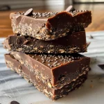 Close-up view of delicious no-bake chocolate chia oat bars stacked on a plate.