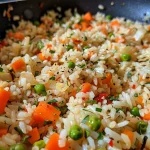 Close-up of One Pan Garlic Veggie Rice with colorful veggies and rice grains.
