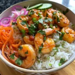 Close-up view of a vibrant shrimp rice bowl topped with spicy mayo and fresh vegetables.