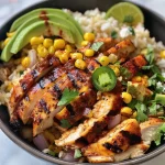 Close-up view of a vibrant Street Corn Chicken Rice Bowl topped with fresh ingredients.
