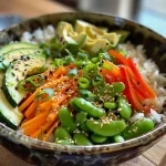 A colorful veggie rice bowl featuring bell peppers, zucchini, carrots, snap peas, and avocado.