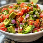 ['Close-up view of a bowl of colorful avocado salsa with diced ingredients.', 'Side angle shot of a vibrant avocado salsa showcasing fresh ingredients.', 'Juicy avocado salsa in a bowl filled with diced tomatoes and onions.', 'Detailed view of a fresh avocado salsa, highlighting the chopped ingredients.']