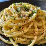 ['Close-up view of vibrant scrambled egg spaghetti with a glossy finish.', 'Side view of delicious egg pasta garnished with herbs and chili flakes.', 'Juicy spaghetti mixed with scrambled eggs and garnished with parsley.', 'Detailed shot of egg pasta showcasing a rich color and texture.']