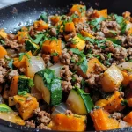 ['A vibrant skillet filled with ground beef, zucchini, and sweet potatoes, garnished with fresh parsley.', 'Close-up view of a savory ground beef and vegetable dish with melted cheese sprinkled on top.', 'A colorful mixture of sautéed ground beef, diced sweet potatoes, and sliced zucchini in a cast-iron skillet.', 'A hearty skillet meal featuring ground beef, zucchini, sweet potato, and fresh spinach, topped with parsley.']