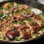 ['Close-up view of a delicious chicken and rice skillet with garnishes.', 'Juicy chicken thighs and rice mixed with herbs and spices in a skillet.', 'High-protein chicken and rice dish, garnished with parsley and lemon.', 'Colorful presentation of chicken and rice with vibrant ingredients in a skillet.']