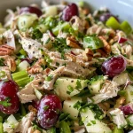 ['Close-up view of a vibrant high protein chicken salad, showcasing colorful ingredients.', 'Side angle of a delicious chicken salad, highlighting its fresh, chopped components.', 'Juicy chicken salad with grapes and apples, captured in bright natural light.', 'Detailed shot of a high protein chicken salad with green onions and pecans.']
