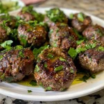 ['Close-up view of juicy Mediterranean Beef Kofta on a plate, garnished with fresh herbs.', 'Side angle of a perfectly grilled Mediterranean Beef Kofta, served with cucumber yogurt sauce.', 'Delicious Mediterranean Beef Kofta, featuring a rich brown color and vibrant garnish.', 'Aromatic Mediterranean Beef Kofta, showcasing its tender texture and fresh ingredients.']