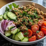 ['Close-up of a Mediterranean bowl filled with ground turkey and quinoa, garnished with fresh vegetables.', 'Side view of a colorful Mediterranean bowl featuring quinoa, ground turkey, and diced vegetables.', 'Juicy Mediterranean bowl with ground turkey, quinoa, cherry tomatoes, and cucumber in a vibrant presentation.', 'Detailed shot of a Mediterranean-style dish showcasing quinoa and ground turkey with fresh herbs.']