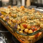 ['Close-up view of a vibrant Mediterranean Chickpea Bake topped with fresh herbs.', 'Side view of a hearty Mediterranean Chickpea Bake, showcasing its golden crust.', 'Juicy Mediterranean Chickpea Bake with vegetables, herbs, and spices, displayed in a rustic dish.', 'Colorful Mediterranean Chickpea Bake filled with chickpeas and vegetables, served in a cozy setting.']