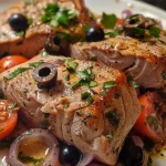 ['Close-up of juicy Mediterranean tuna steaks garnished with herbs.', 'Side view of perfectly cooked tuna steaks with vibrant toppings.', 'Detailed image of Mediterranean-style tuna steaks with olives and herbs.', 'Freshly plated Mediterranean tuna steaks highlighting rich colors and textures.']