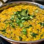 ['Close-up of a golden-brown Moong Dal Chilla on a plate, garnished with herbs.', 'Side view of a crispy Moong Dal Chilla with colorful ingredients visible.', 'Juicy Moong Dal Chilla showcasing texture and spices, captured from a close angle.', 'A plated Moong Dal Chilla, with green spinach and herbs, highlighting its vibrant colors.']