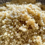 ['Close-up view of quinoa flour in a bowl with a smooth texture.', 'Side angle of fluffy quinoa flour with grains visible, set on a rustic table.', 'Detailed shot of freshly made quinoa flour, highlighting its light color and fine consistency.', 'Close-up photo of quinoa flour spilling from a measuring cup, emphasizing its fine texture.']