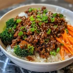 ['A close-up view of a Spicy Korean Beef Bowl featuring ground beef, broccoli, carrots, and rice.', 'A vibrant Spicy Korean Beef Bowl displayed with colorful vegetables and garnished with sesame seeds.', 'Detailed image of a Spicy Korean Beef Bowl with juicy beef, steamed broccoli, and rice in a bowl.', 'A side view of a Spicy Korean Beef Bowl showcasing the rich colors and textures of its ingredients.']