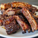 ['Close-up view of succulent Five Spice BBQ beef ribs on a plate.', 'Juicy beef short ribs seasoned with Chinese Five Spice, displayed side view.', 'Deliciously glazed beef ribs, showcasing rich color and texture.', 'Appetizing bone-in beef ribs with a glossy BBQ sauce visible.']