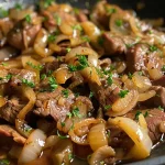 ['Close-up view of cooked beef liver and onions on a plate.', 'Juicy beef liver sliced and served with sautéed onions.', 'Side view of tender beef liver paired with caramelized onions.', 'Appetizing dish of beef liver and onions, garnished and plated.']