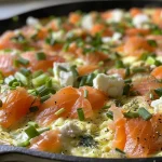 ['Close-up view of a smoked salmon frittata featuring a golden crust and vibrant herbs.', 'Side view of a delicious smoked salmon frittata with visible pieces of salmon and herbs.', 'Juicy smoked salmon frittata with a colorful mix of vegetables and a creamy texture.', 'Detailed image of a frittata, showcasing chunks of smoked salmon and fresh green toppings.']