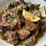 ['Close-up of juicy Greek beef stew with vibrant vegetables.', 'Side view of a plate filled with tender Greek beef, garnished with parsley.', 'Delicious Greek beef dish featuring colorful bell peppers and onions.', 'Mouth-watering Greek beef with drizzles of olive oil and lemon wedges.']