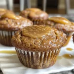 Close-up side view of freshly baked apple butter muffins with a golden-brown top.